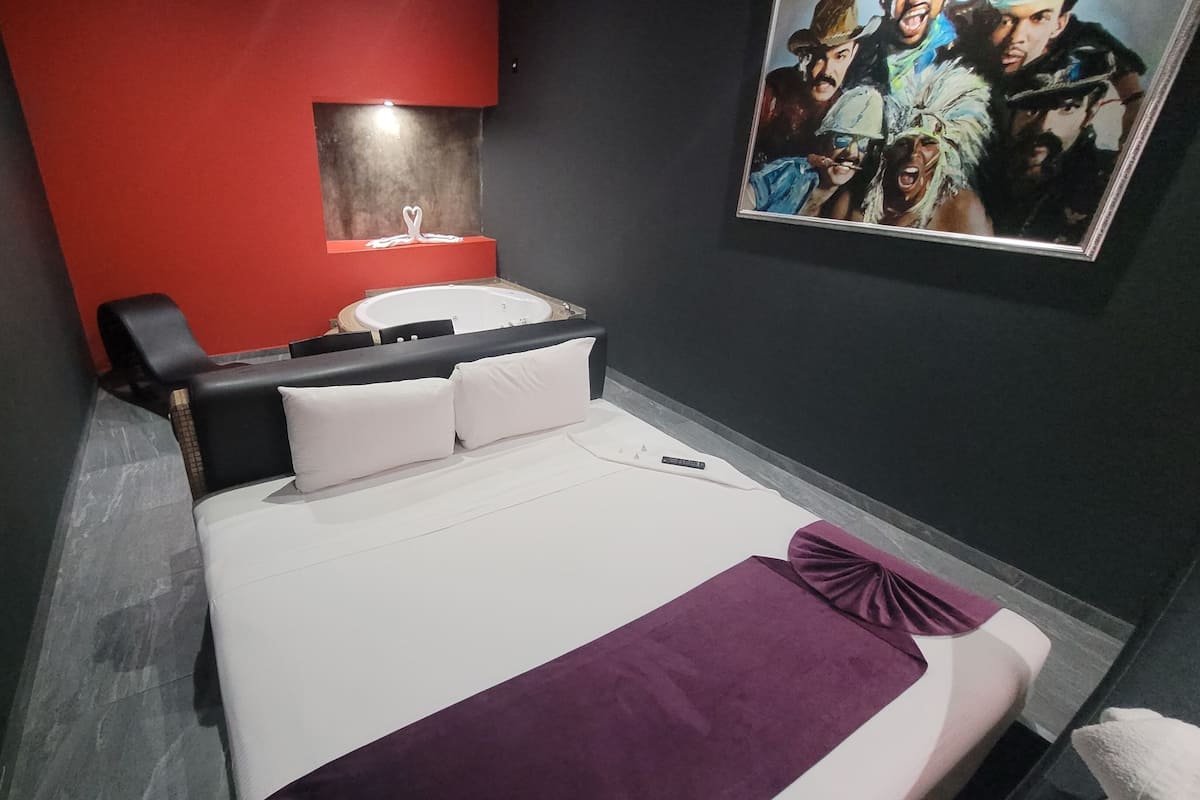 A modern hotel room with a bed, a desk, and a chair.