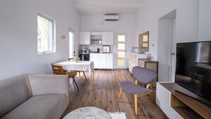 A compact living space with a dining area, kitchenette, and a TV. - Queen size loft in nature right in the city (Toronto)