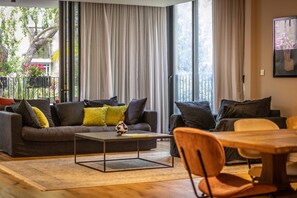 Een moderne woonkamer met een bank, salontafel en eethoek.