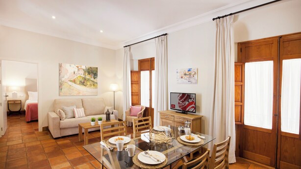 Comedor con mesa de vidrio, sillas de madera y una mesa de buffet.