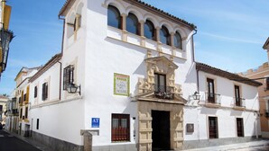 A white building with a balcony, a sign reading "La Casa del Aceite", and a blue sign indicating a restaurant. - El Alminar en Apartamentos La Casa del Aceite (Cordoba)
