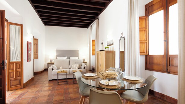 A dining area with a glass table, chairs, and a buffet setup.