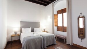 A double bed with two bedside tables, a bench, and a mirror.