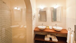 Ein Badezimmer mit zwei Waschbecken, einer Dusche und einem Spiegel.
