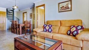 A living room with a sofa, coffee table, and dining area with chairs and a table. - Marysol 32 - Penthouse in Benalmádena with swimming pool, 2 terraces, garage (Benalmádena)