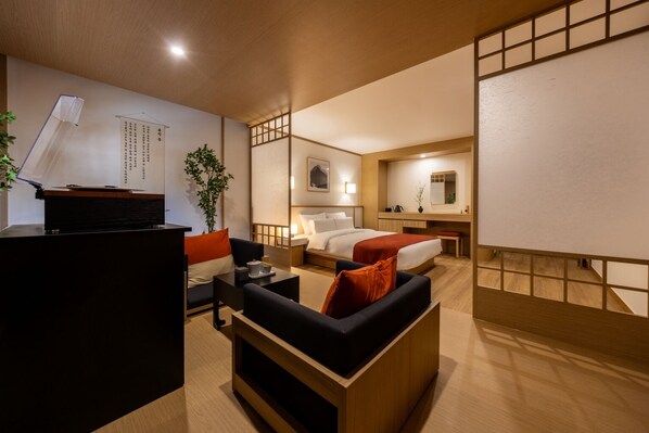 A hotel room with a bed, a desk, a sofa, and a small table.