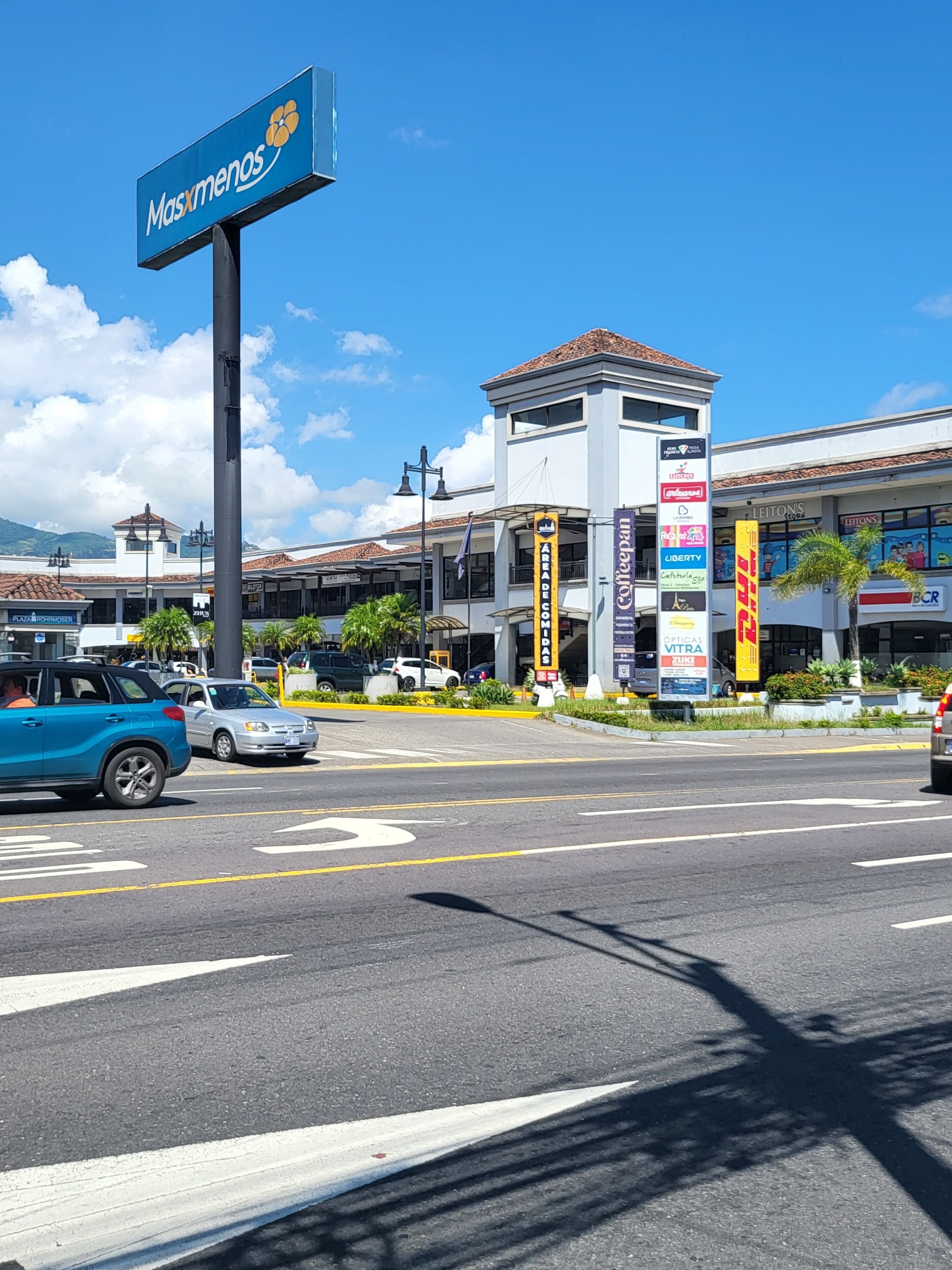 A commercial building with a sign for 'Masxmenos' and various storefronts including 'Leitons' and 'Coffee Bean'.