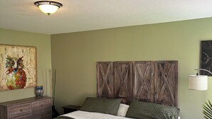 A bedroom with a bed, dresser, and artwork on the wall. - Three bedroom home, pets allowed.  (Cypress)
