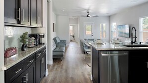 Una cocina moderna con armarios oscuros, una isla central y un lavavajillas integrado.