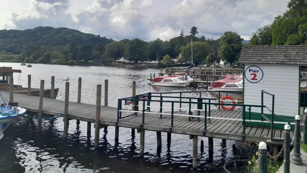 A pier with wooden walkways, boats docked, and a sign indicating 'Pier 2'.
