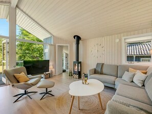 A modern living room with a fireplace, a sofa, a TV, and a dining area.