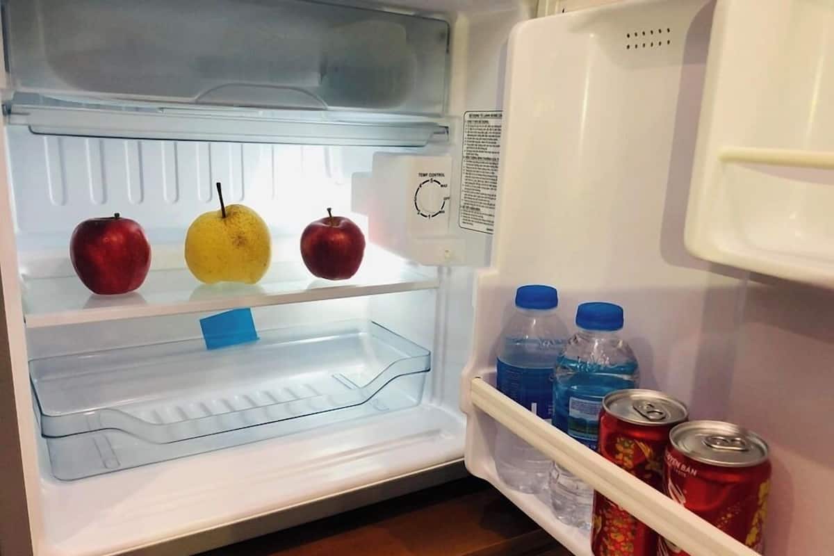 An open refrigerator with fruits and beverages.