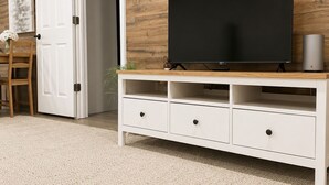 A modern living room with a flat-screen TV on a white entertainment unit, a wooden wall, and a door leading to another room. - Private 1BR GuestHouse Near Charlotte Pet Friendly (Indian Trail)