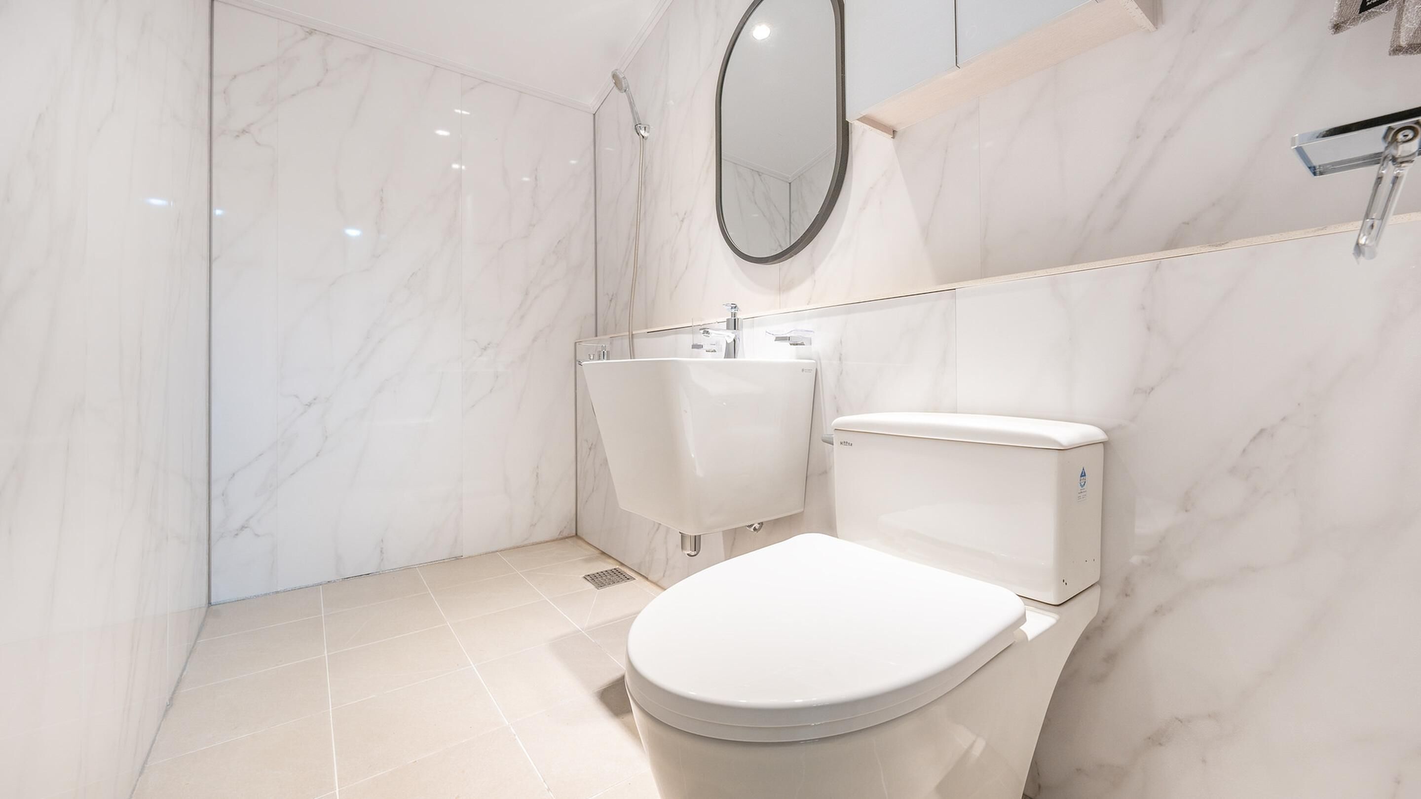 Een moderne badkamer met toilet, bidet en douche.