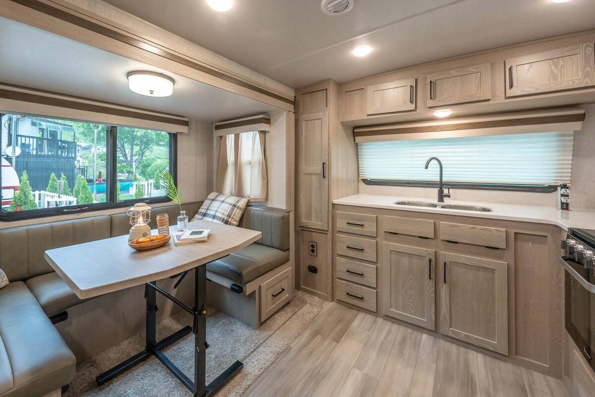 Cocina compacta para autocaravana con comedor, lavabo y estufa.