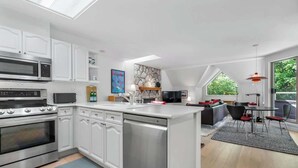 A modern kitchen with white cabinetry, stainless steel appliances, and a large island. - Golf course townhouse w/ free shuttle, parking (Whistler)