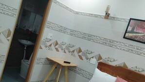Une chambre d’hôtel équipée d’un lit, d’une petite table, d’un lavabo et d’un appareil de climatisation.
