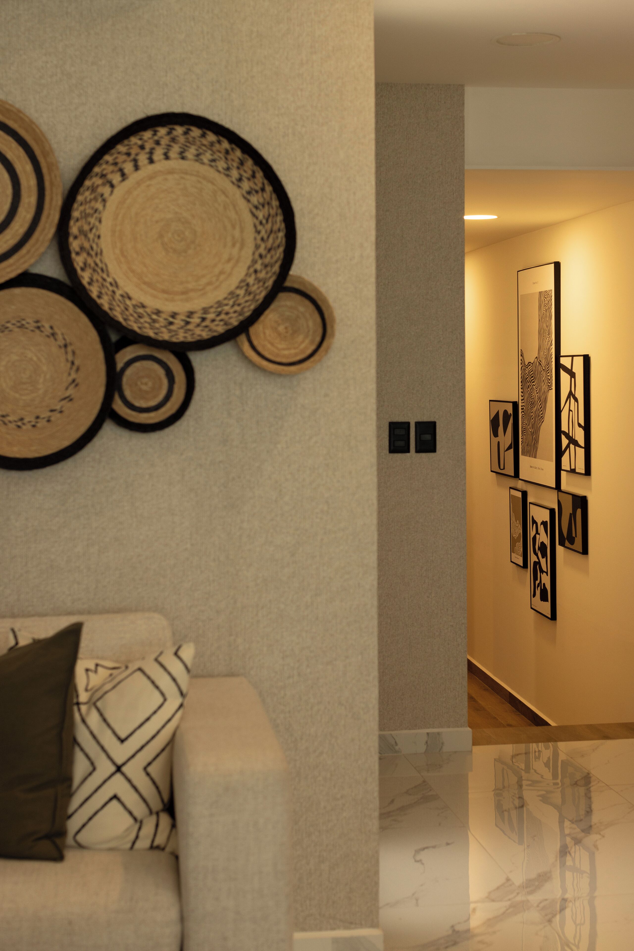 A modern interior with a sofa, patterned cushions, and wall-mounted decor.