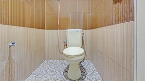 Ein kleines Badezimmer mit Toilette, Dusche und gefliesten Wänden.