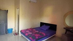 Un dormitorio con cama, armario, cesto azul y ventilador de techo.