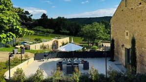 A patio with outdoor seating, a barbecue grill, and a stone building in the background. - Dordogne, Luxury Cottage, Domme and Sarlat, Hamlet Château Giverzac, With Airco (Domme)