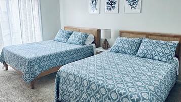 Ein Schlafzimmer mit zwei Betten, einem Deckenventilator und drei Wandbildern.