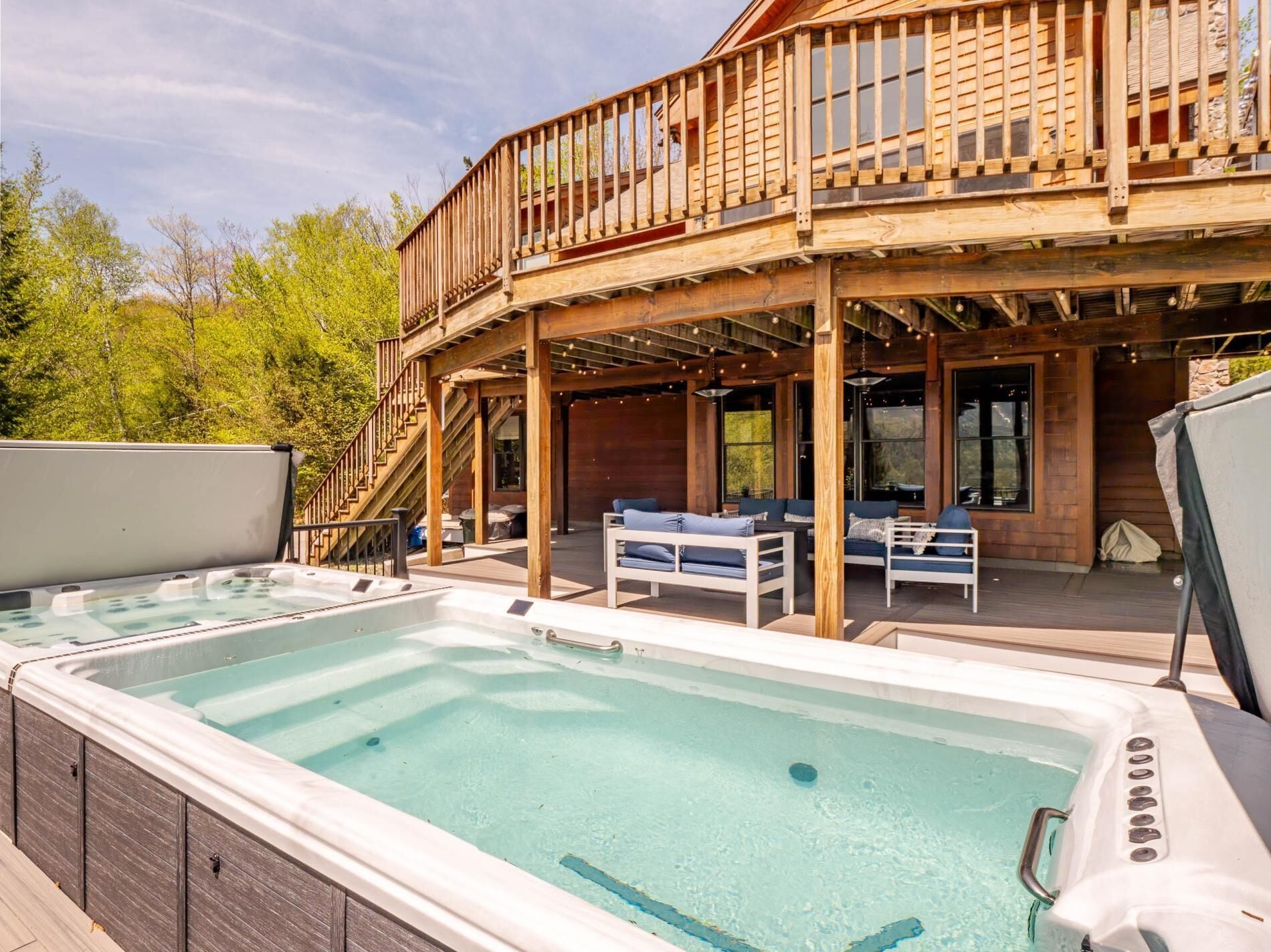 A wooden deck with outdoor seating and a hot tub area.