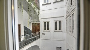 A multi-level interior with a central staircase, white walls, and a balcony with hanging plants. - Casa Arpeggio: An elegant and welcoming apartment located in the center of Maiori and a few meters from the sea. (Maiori)