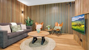 A modern living room with a sofa, a coffee table, and two chairs. - Bright on the River (Buffalo Apartment 1) (Bright)