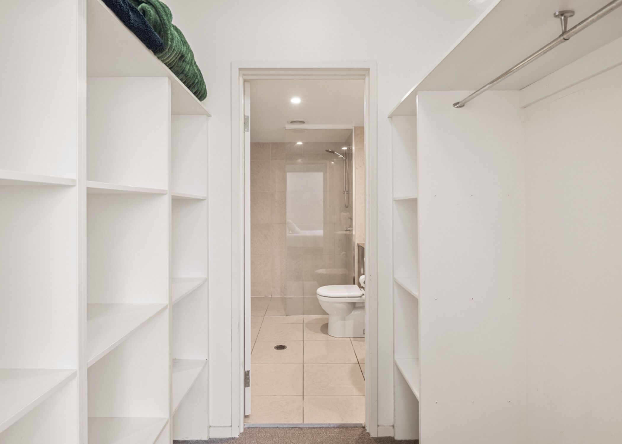 A modern bathroom with a toilet, shower, and a glass-enclosed shower area.