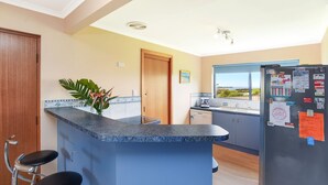 Una cocina con encimera azul, un refrigerador y vistas al exterior.