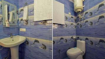 A bathroom with blue tiles featuring dolphin patterns, a white sink, and a toilet.