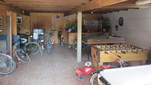 A room with bicycles, a foosball table, and a dartboard. - Hoffarth Apartment with Private Terrace, Garden, and Wi-Fi (Gelting)
