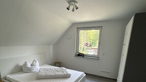 Ein Schlafzimmer mit Bett, Fenster und Deckenventilator.