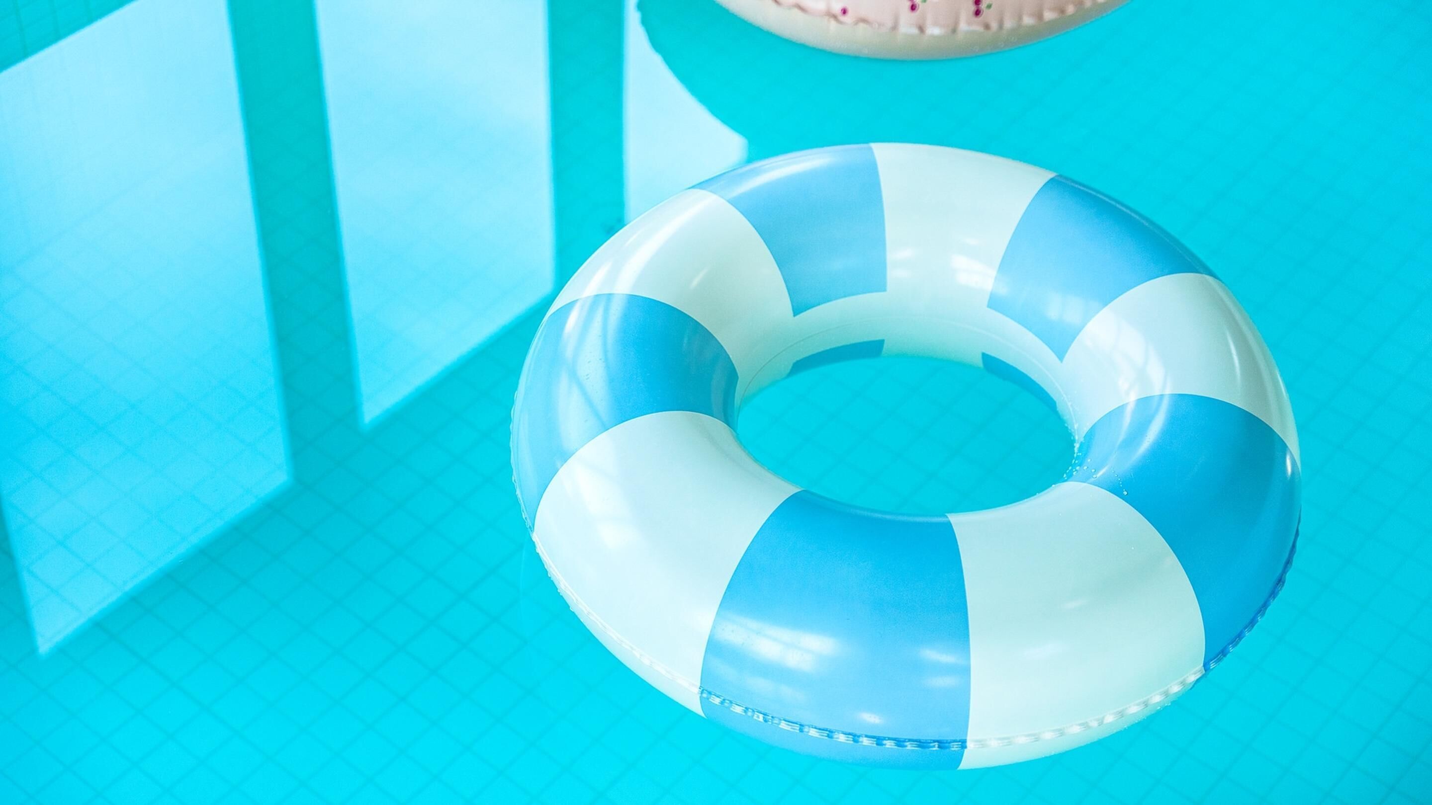 Un flotador de piscina azul y blanco, en forma de aro.
