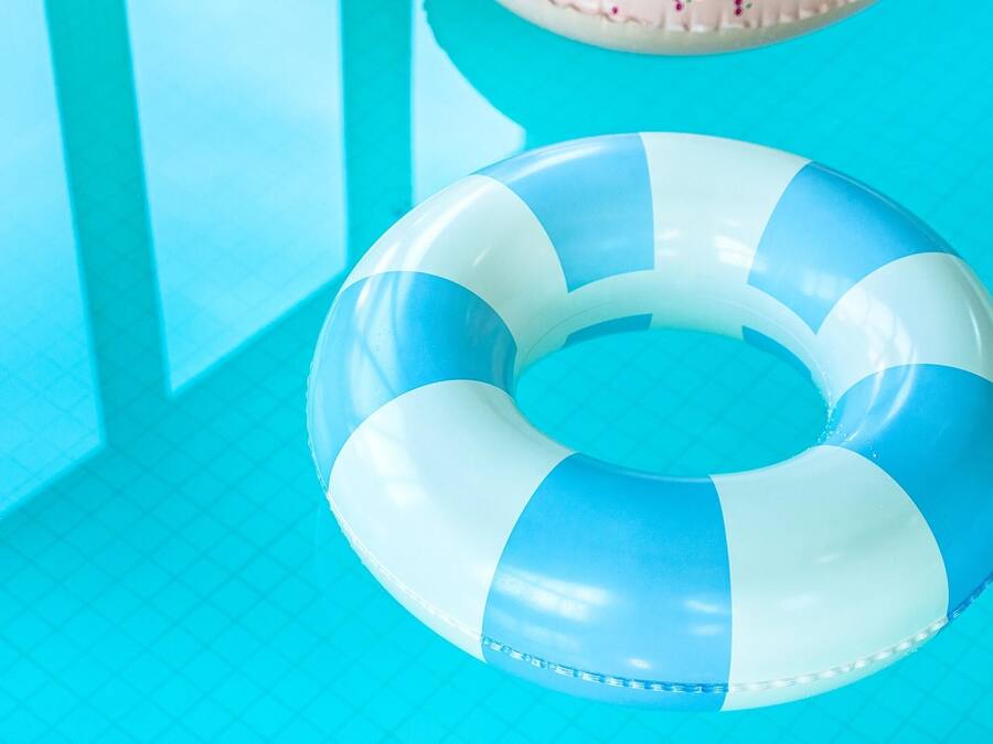 Un flotador de piscina azul y blanco, en forma de aro.