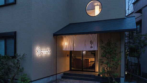 Un bâtiment doté d’une façade à motifs, d’une fenêtre circulaire et d’une enseigne avec des caractères japonais.