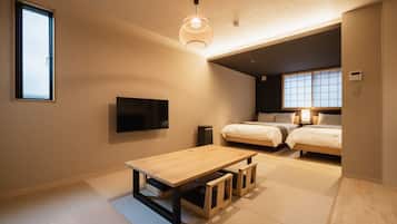 A modern, compact bedroom with a single bed, a small table, a TV, and a window with a view.
