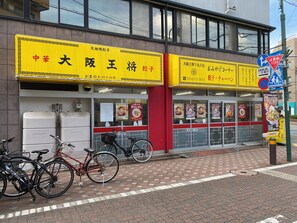 Un restaurante con un letrero amarillo, bicicletas estacionadas afuera y una señal de paso de peatones.
