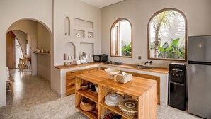 Una cocina moderna con una isla central, estantes empotrados y un refrigerador grande.
