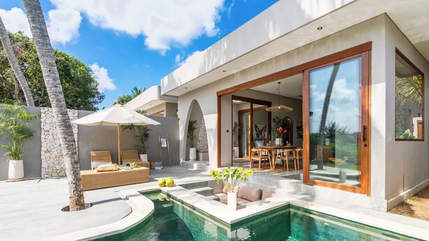 Una casa moderna con piscina, mobiliario exterior y zona de patio.