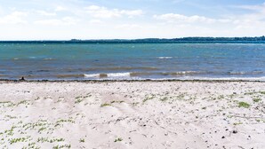 Una playa con arena y mar tranquilo.