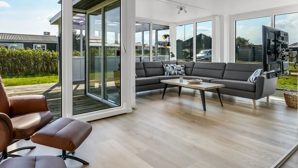 A modern living room with a sectional sofa, a coffee table, and a leather chair. - "Myrte" - 300m from the sea by Interhome (Blokhus)