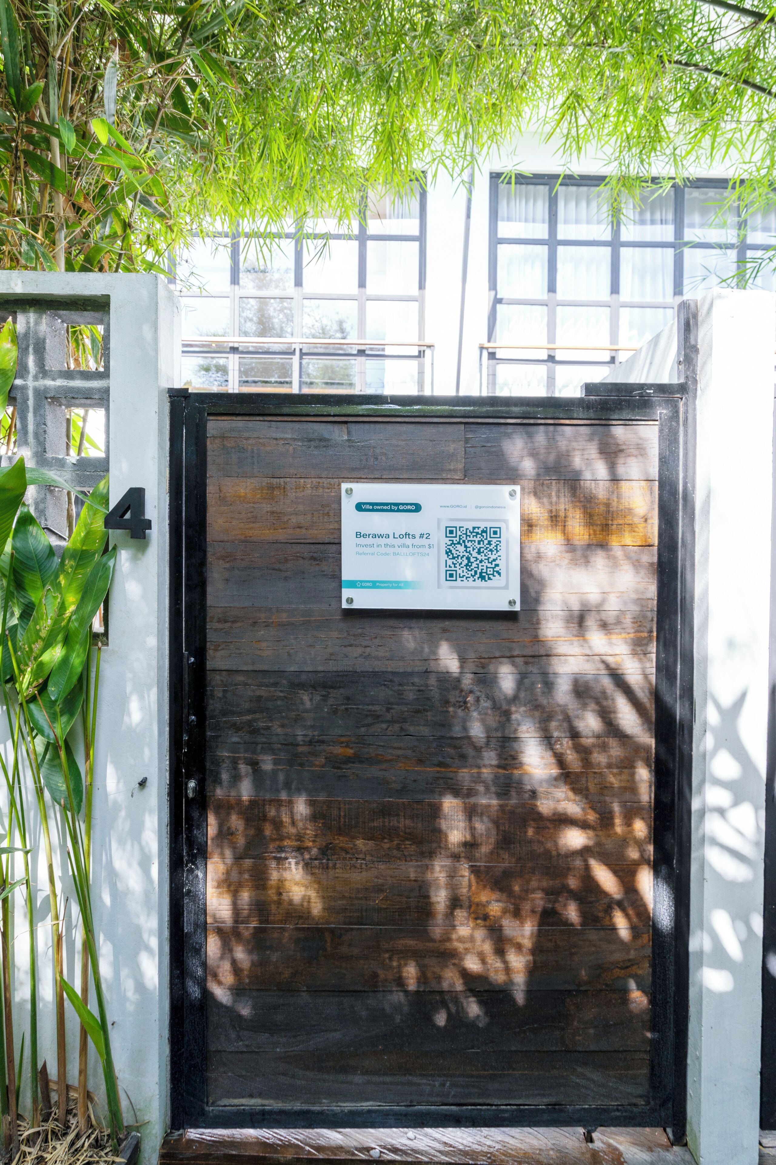 A gated entrance with a QR code sign for Berawood Lofts #2.