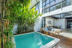 Una piscina al aire libre, sillones reclinables de piscina