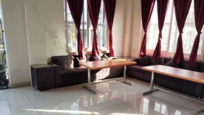 Una habitación amplia con un ventanal grande, un sofá, una mesa y una silla.