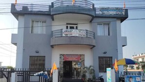 Un edificio de dos pisos con un letrero que dice "PENMANCHAL RESTAURANT" y un cartel de bienvenida.