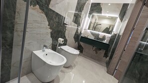 A modern bathroom with a bidet, a toilet, a sink, and a mirror. - Pietra Viva - Suite & Relax (Veglie)