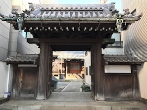Ein traditionelles japanisches Tor mit hölzernen Säulen und einem Ziegeldach.