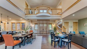 A spacious, multi-level living area with a dining table, chairs, and a sofa.